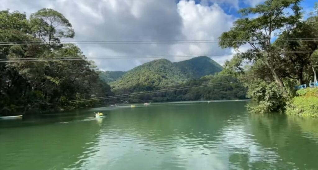 पहाड़ो और जंगल के बीच बनी हनुमान लेक जहाँ लोग कायकिंग करते हुए।